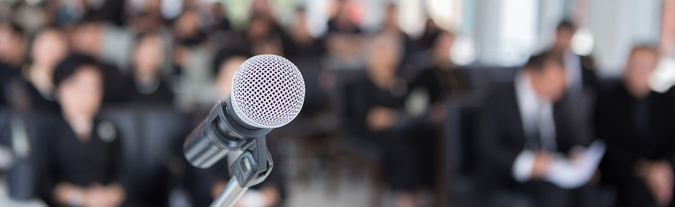 A microphone before a crowded meeting