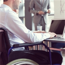 Man in a wheelchair working on laptop